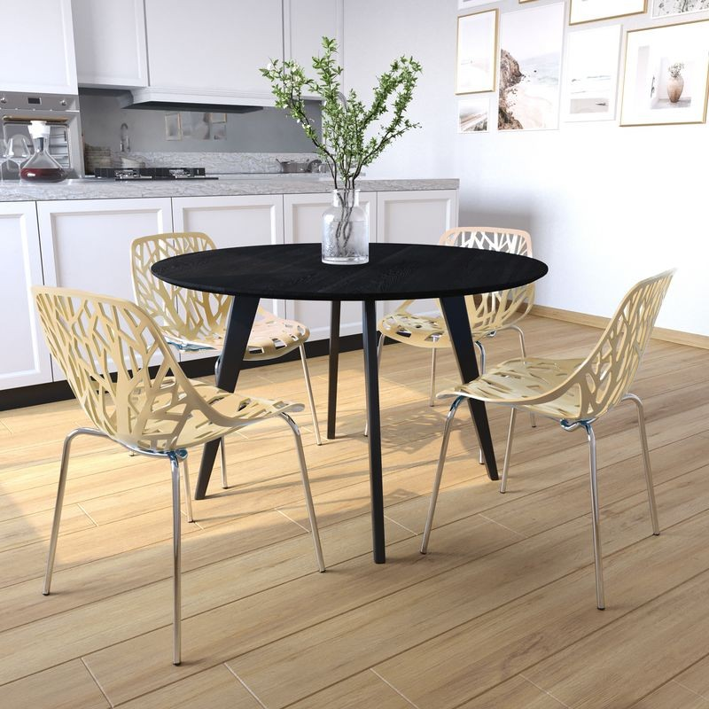 Black round dining table with four beige chairs in a kitchen setting.