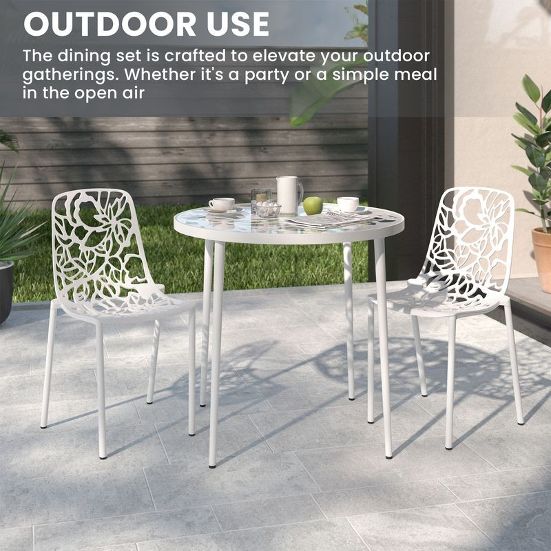 Outdoor dining set with white chairs and table on a patio.