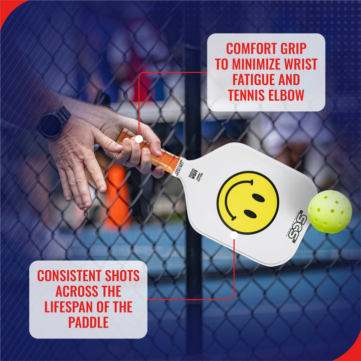 Pickleball paddle with smiley face design held by a hand, with text about comfort grip and product features.