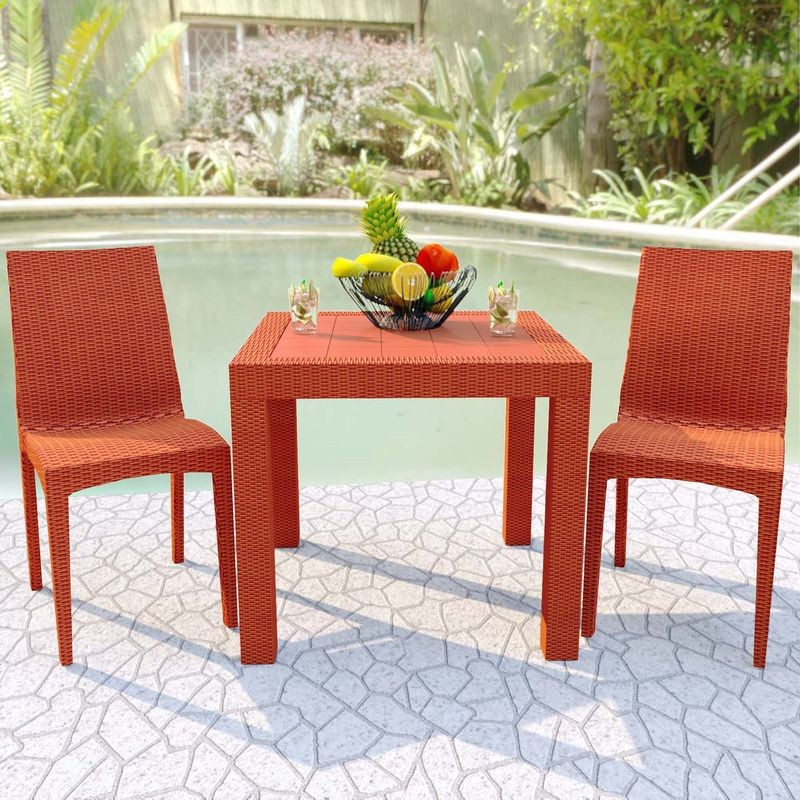 LeisureMod Weave Mace Indoor/Outdoor Dining Chair (Armless) Orange at Table.
