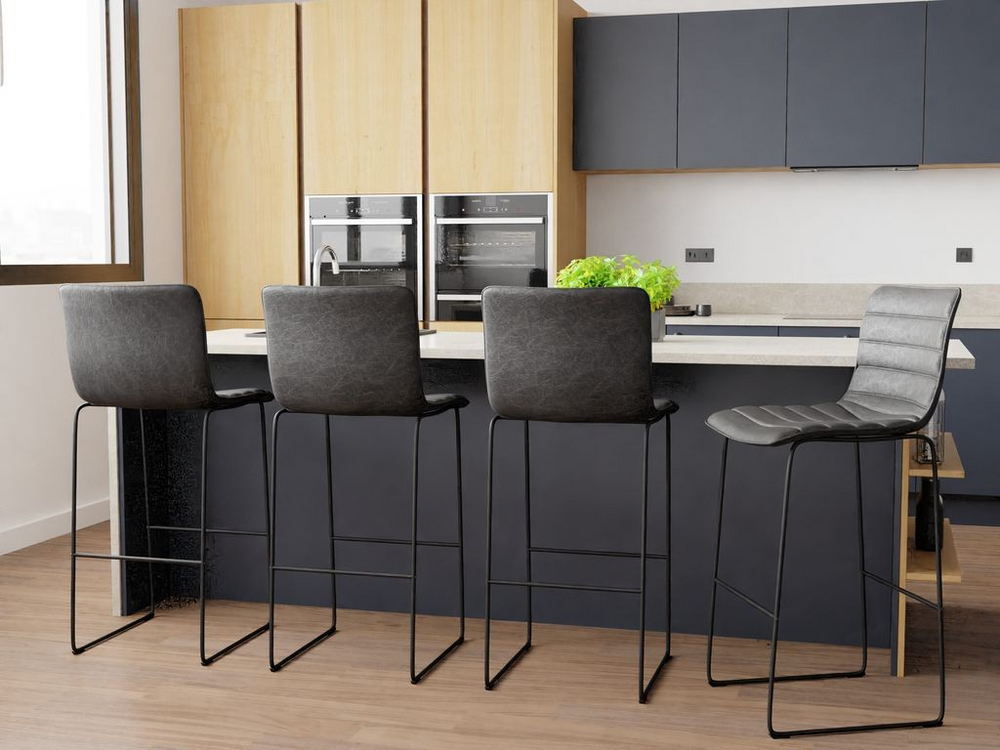 LeisureMod Brooklyn 29.9" Modern Leather Bar Stool with Black Iron Base and Footrest at Bar.