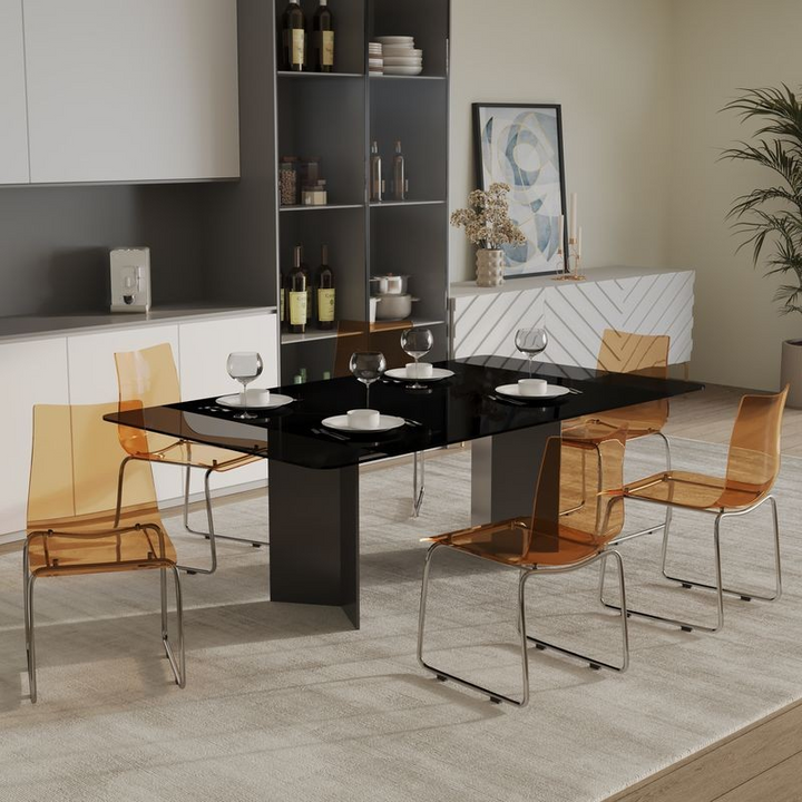 Dining room with a black glass table and orange chairs.