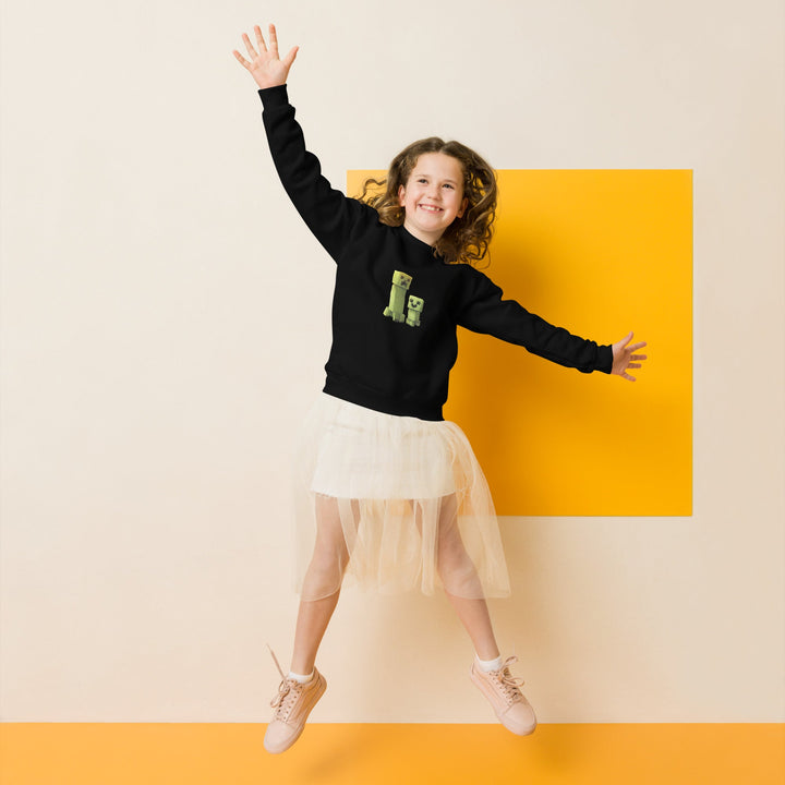 Child wearing a black sweater with green letters and a white skirt, jumping against a yellow and beige background.