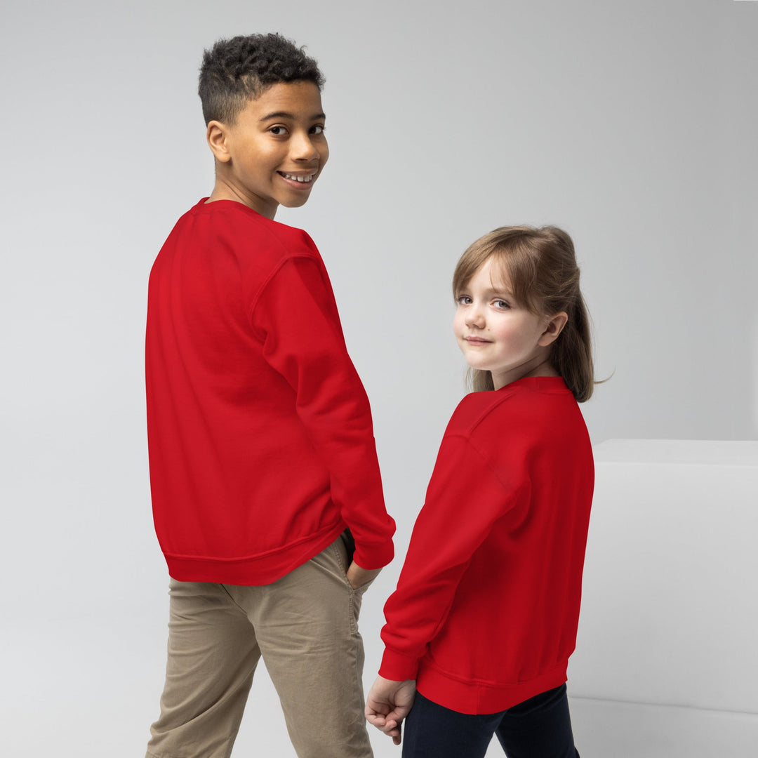 Two children wearing red sweatshirts standing back-to-back against a plain background.