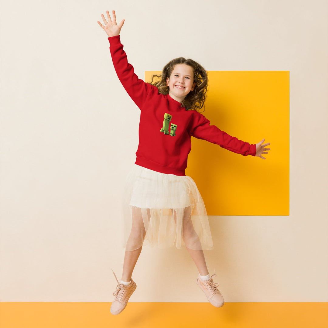 Child wearing a red sweater with a green dinosaur design, white skirt, and beige shoes, jumping against a yellow background.