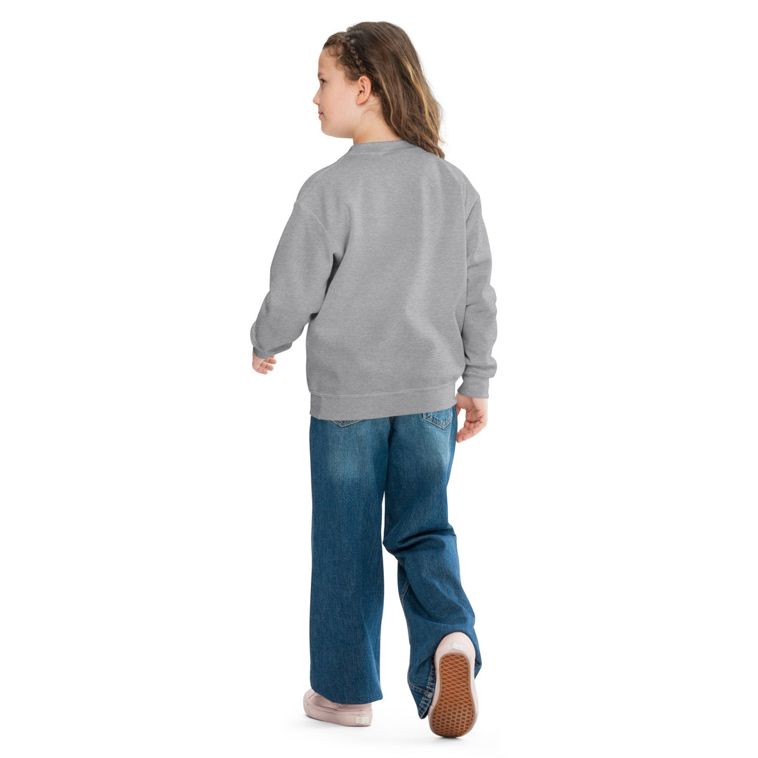 Child wearing a gray sweatshirt and blue jeans on a white background.