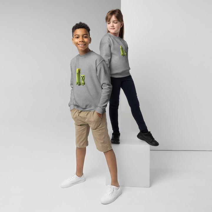 Two children wearing gray hoodies with green graphic designs on a white background.