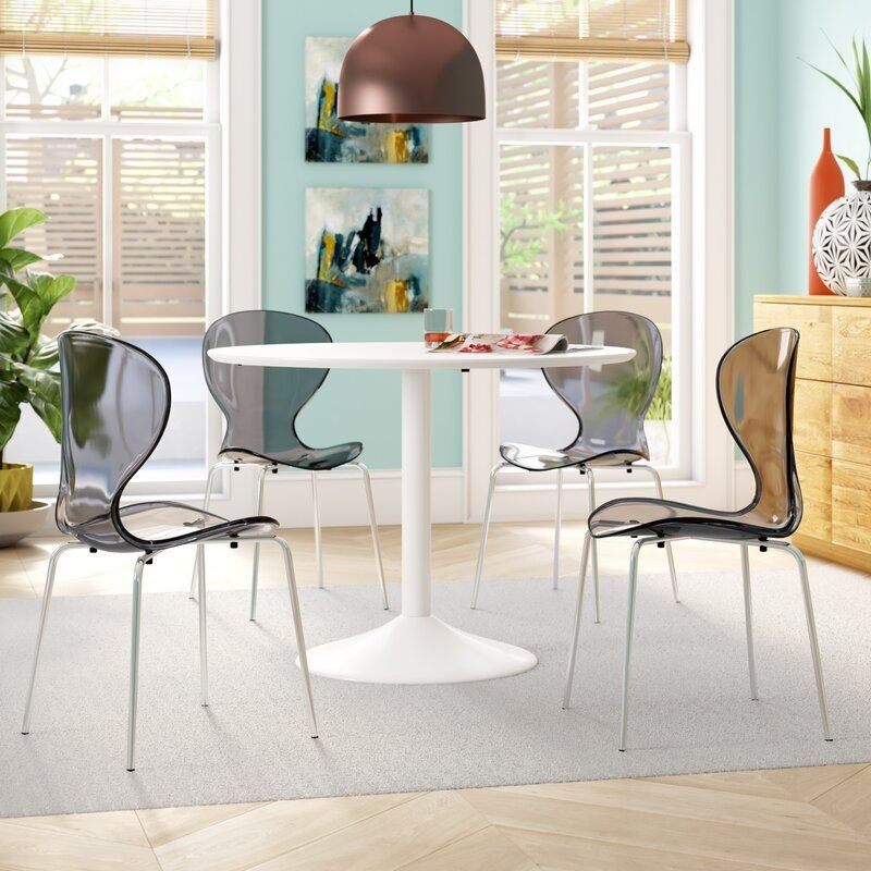 LeisureMod Modern Oyster Transparent Side Chair Black at Table.